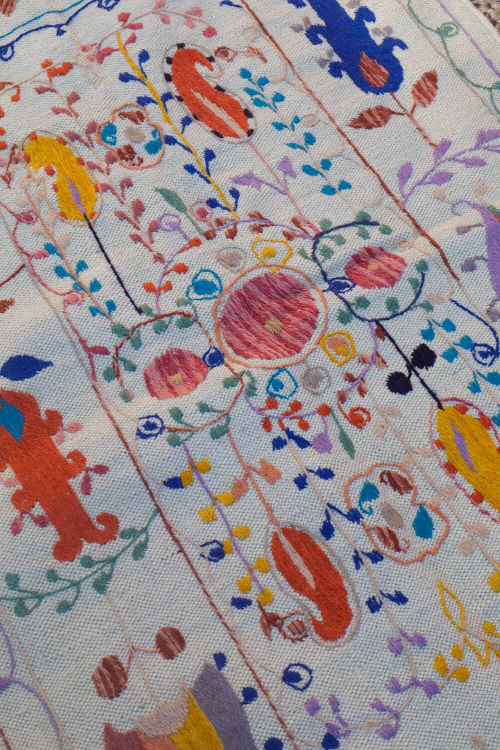 White suzani kilim rug with embroidered colorful patterns