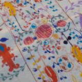White suzani kilim rug with embroidered colorful patterns