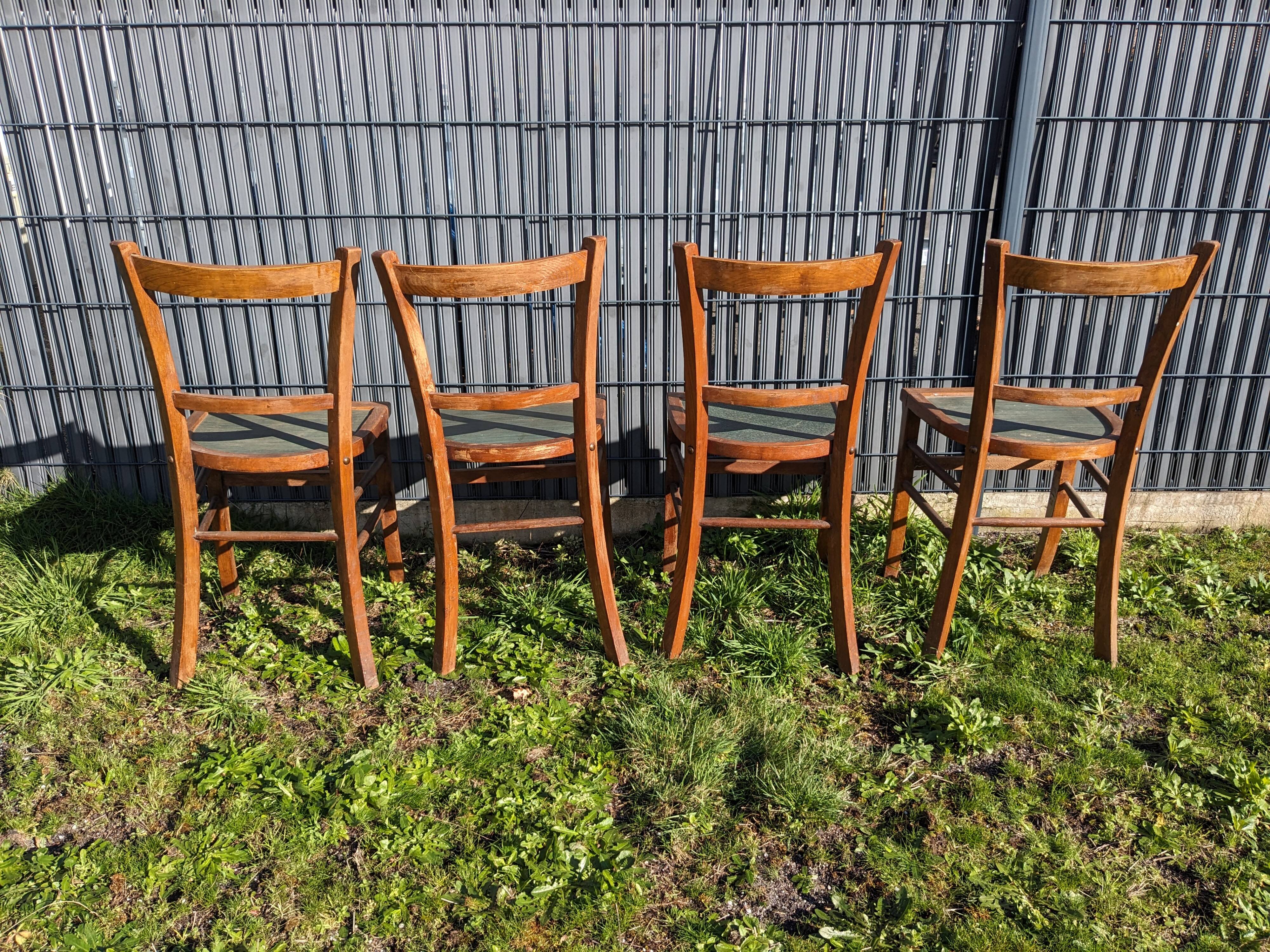 Set of four wooden bistro chairs, green seat, mid-20th century.