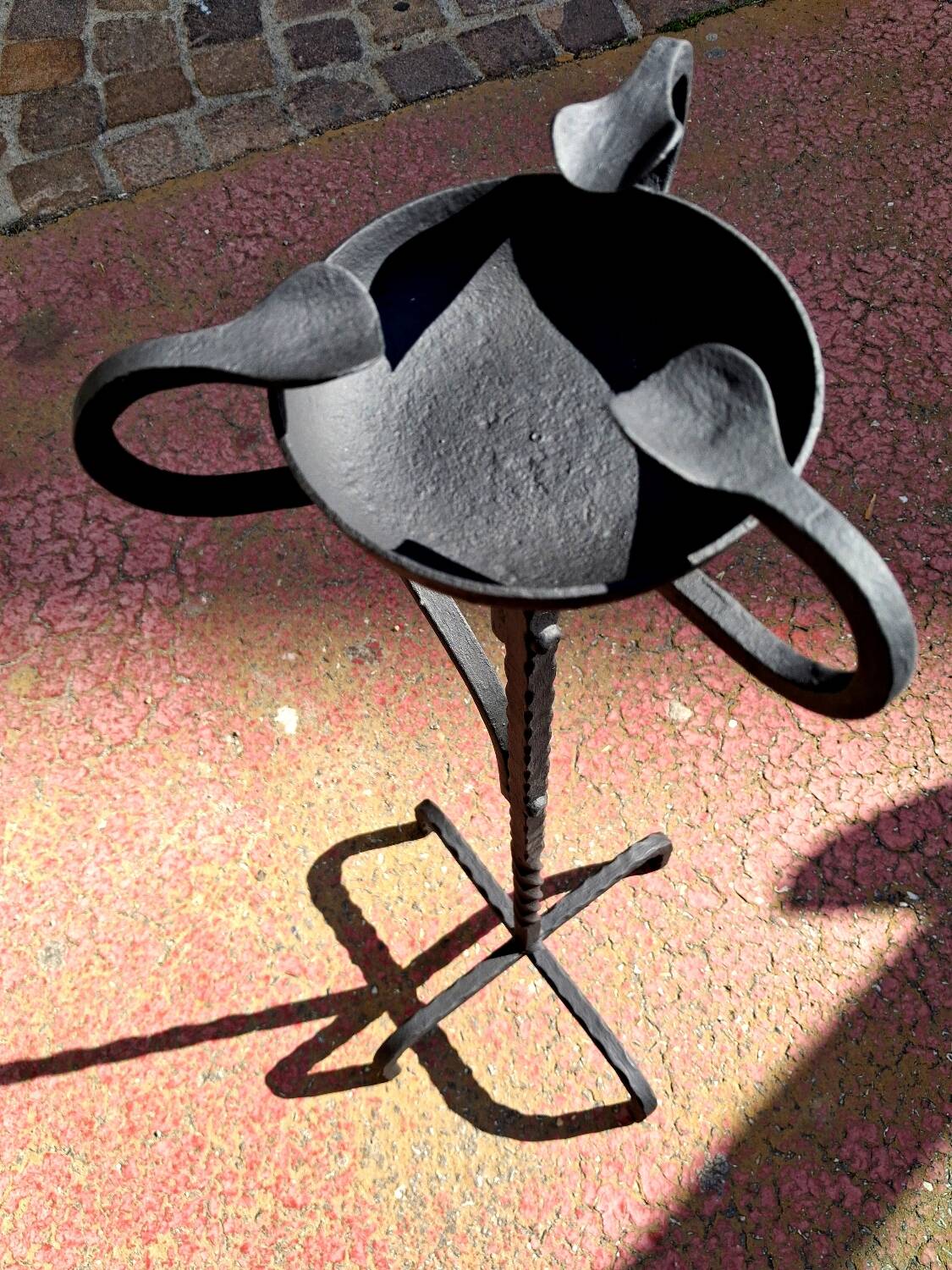 Old ashtray on twisted hammered wrought iron legs, vintage decor.