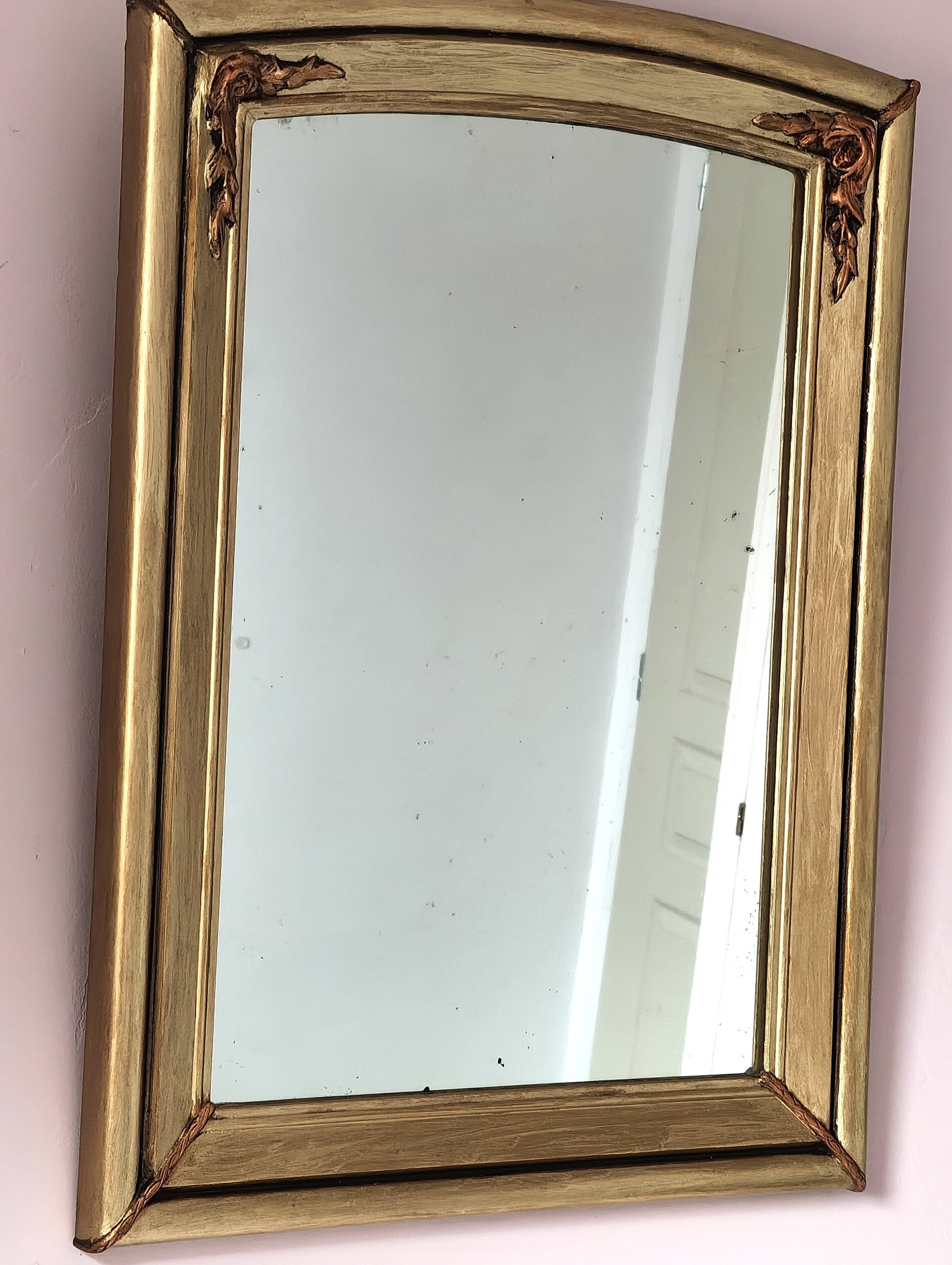 Art Deco mirror in gilded wood with curved floral decorations.