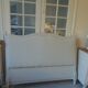 Louis XV style headboard with pearl grey patina, upholstered in off-white bouclette.