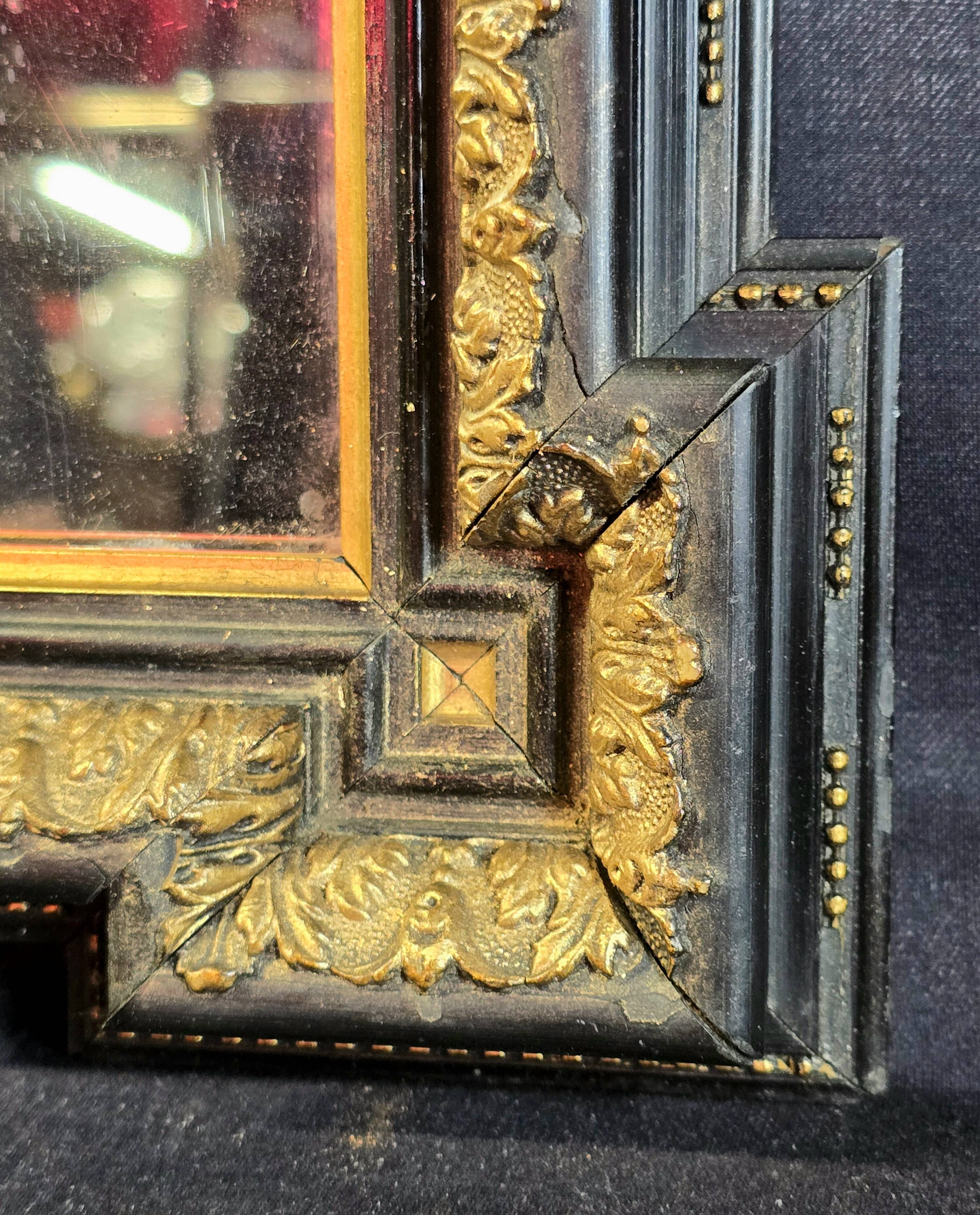 Napoleon III mirror in blackened wood and gilded decoration, second half of the 19th century.