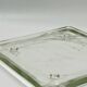 Vintage square serving tray in pale green tinted transparent glass with raised feet.