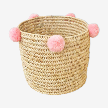 Moroccan basket with pale pink pompoms made of palm fiber