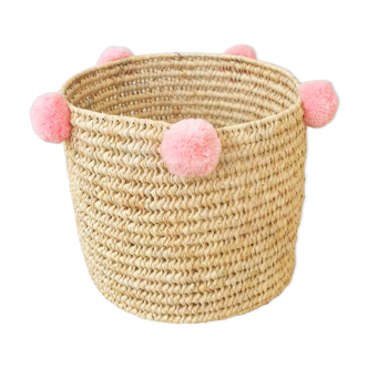 Moroccan basket with pale pink pompoms made of palm fiber