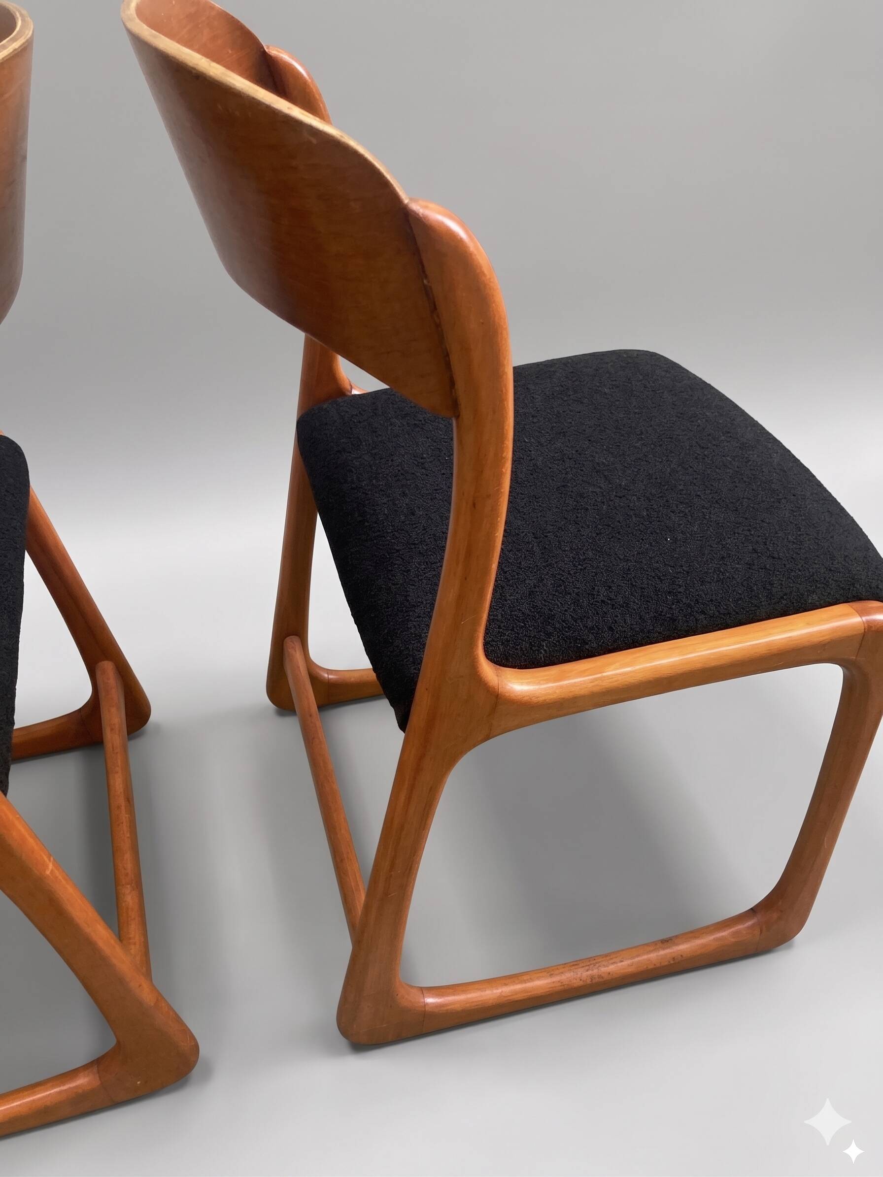 Pair of vintage Baumann sled chairs with curved wood in honey colour.