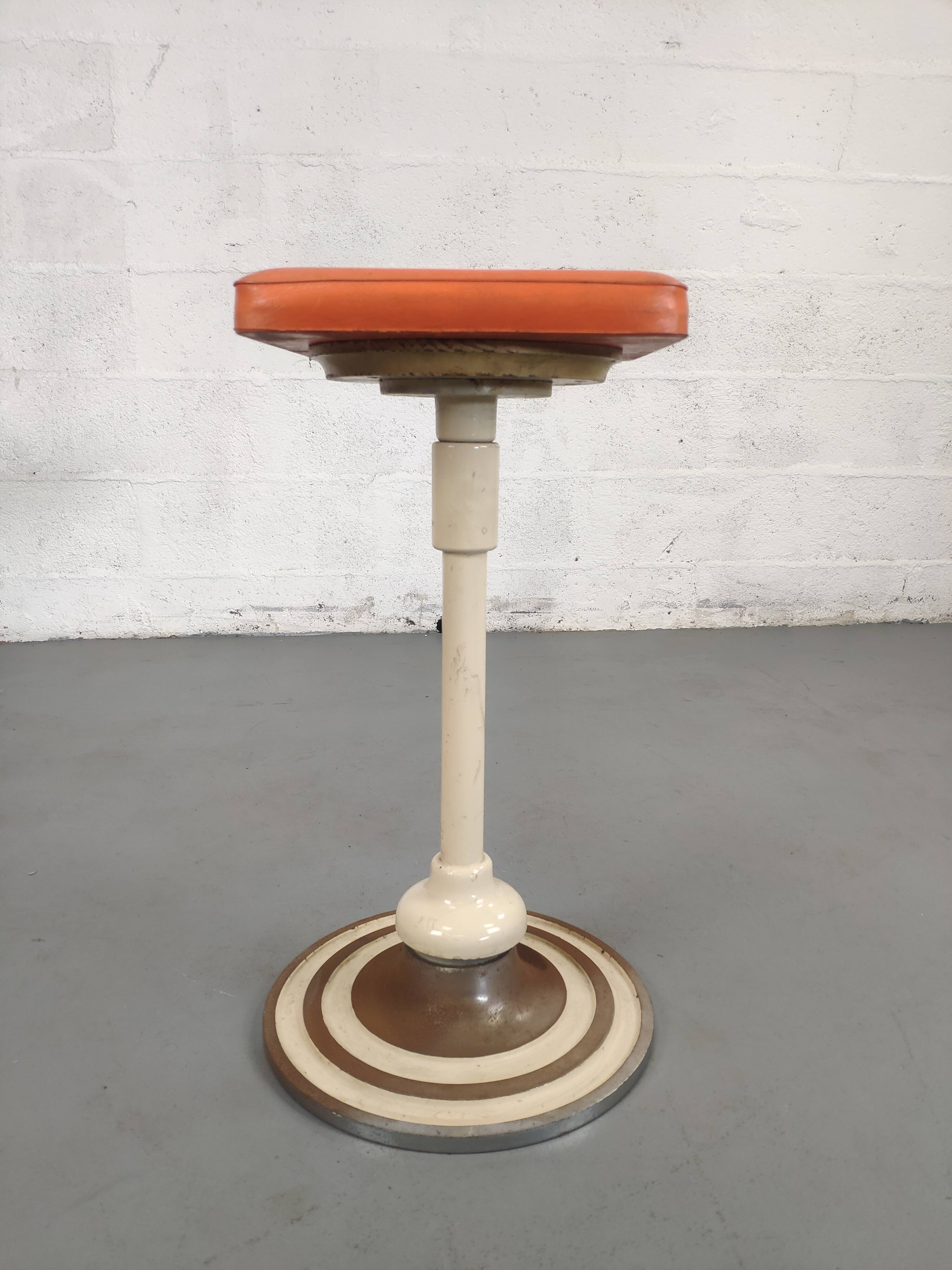 Old swivel orange sitting dentist stool