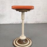 Old swivel orange sitting dentist stool