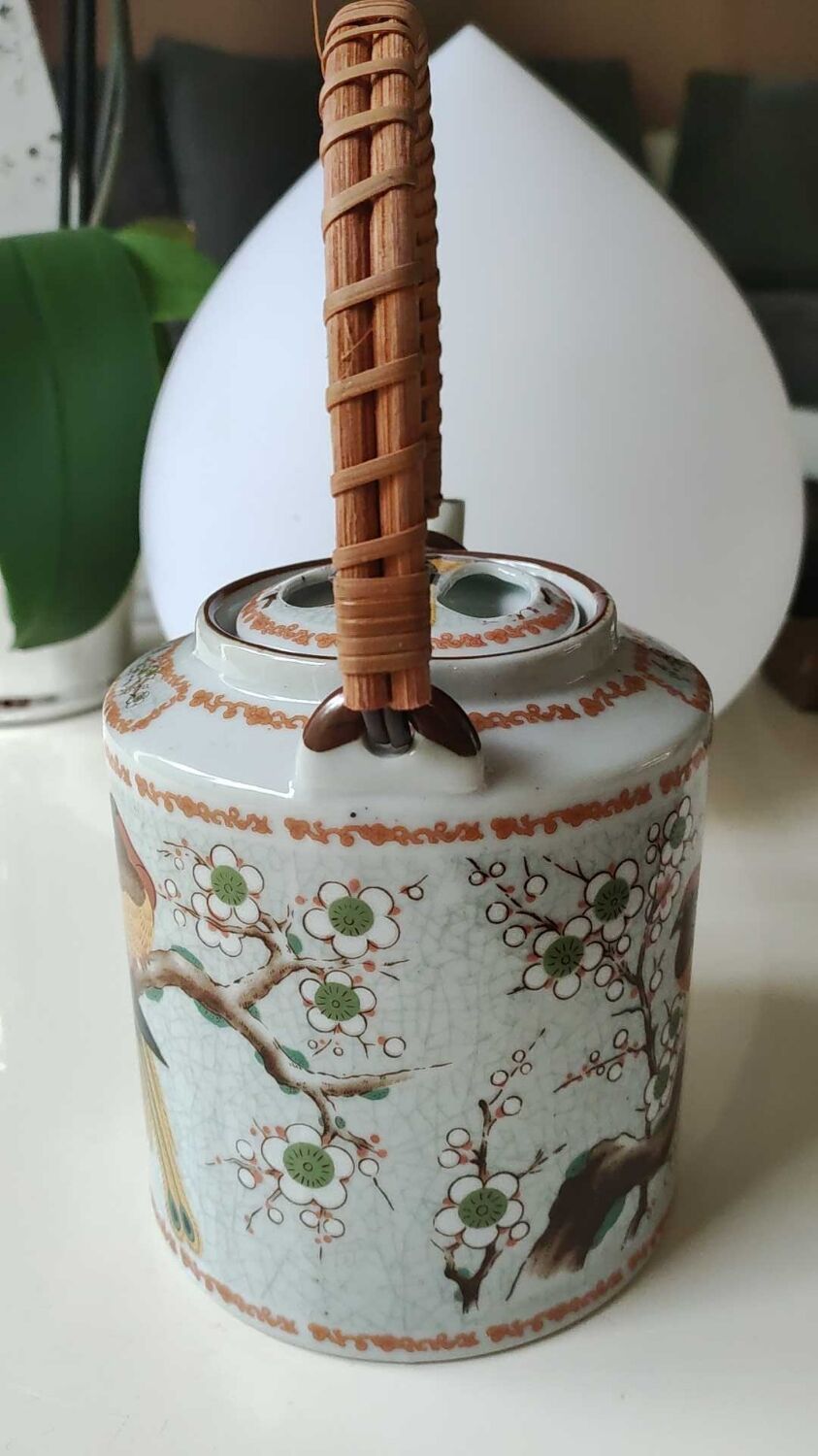 Japanese ceramic teapot. bird/paradise motifs/cherry trees. bamboo/rattan braided handle