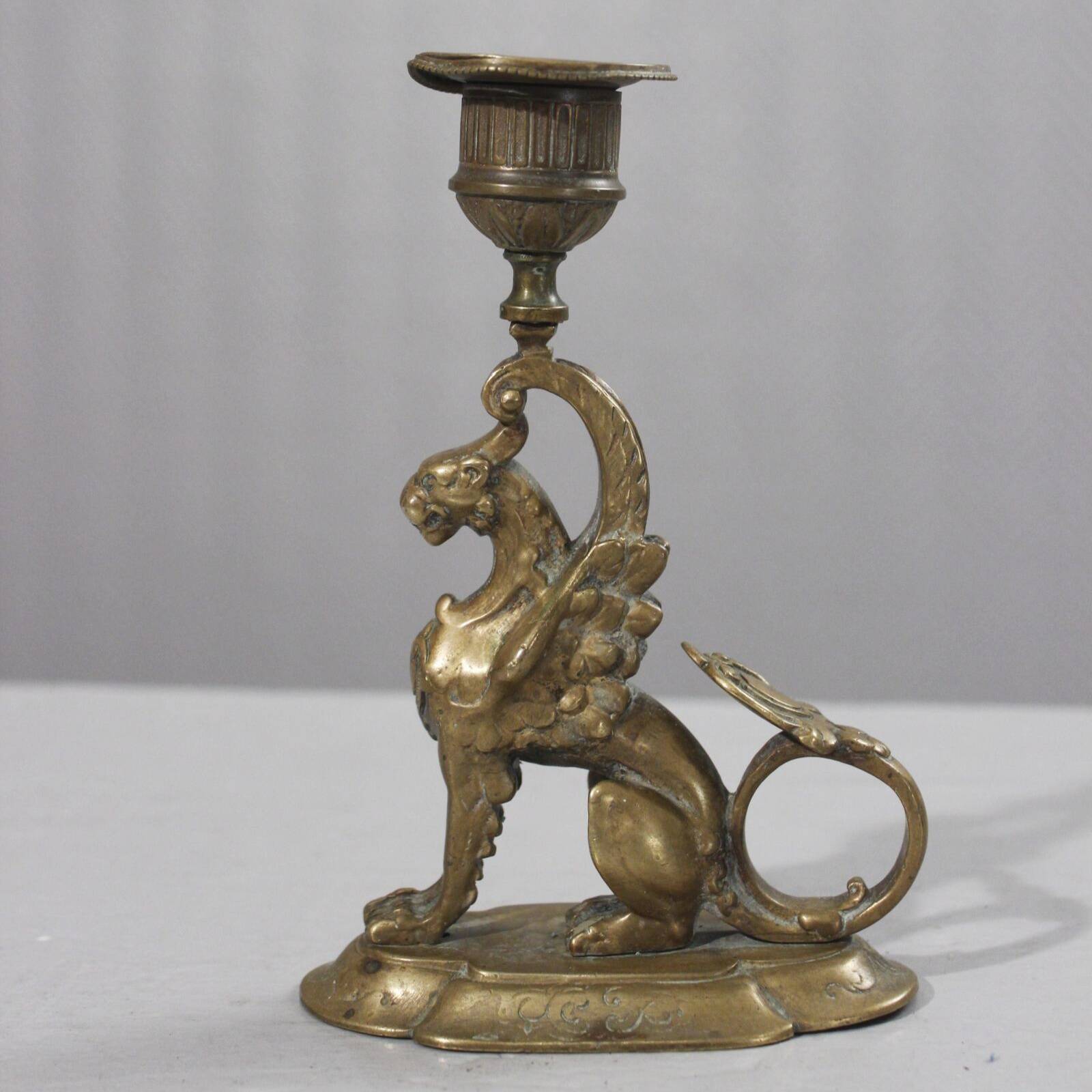 Handheld candlestick in bronze featuring a griffin, 19th-century Empire style.