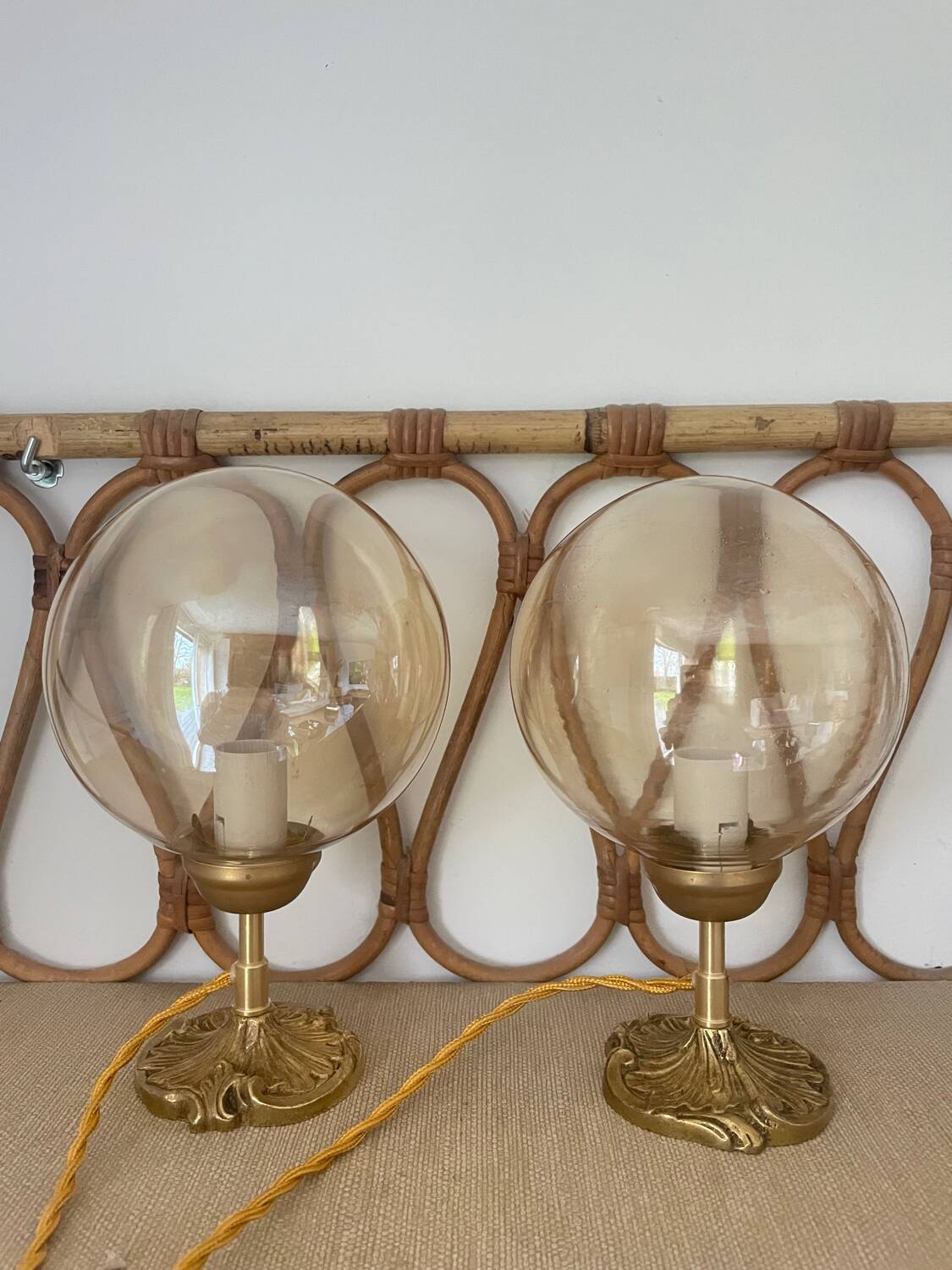 2 bedside lamps with round amber glass globes and gold metal.