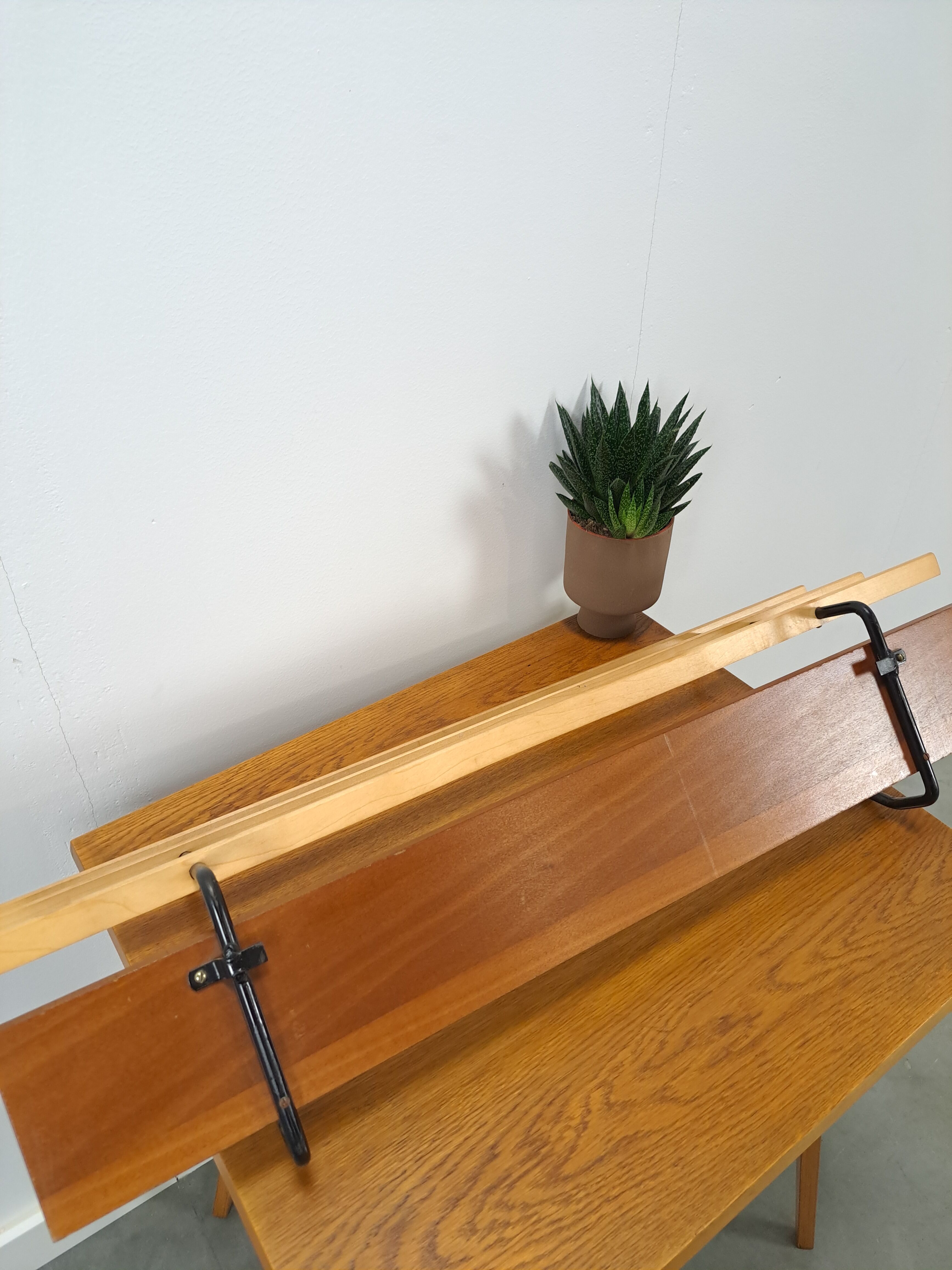 Vintage wall coat rack with black hooks and light wood