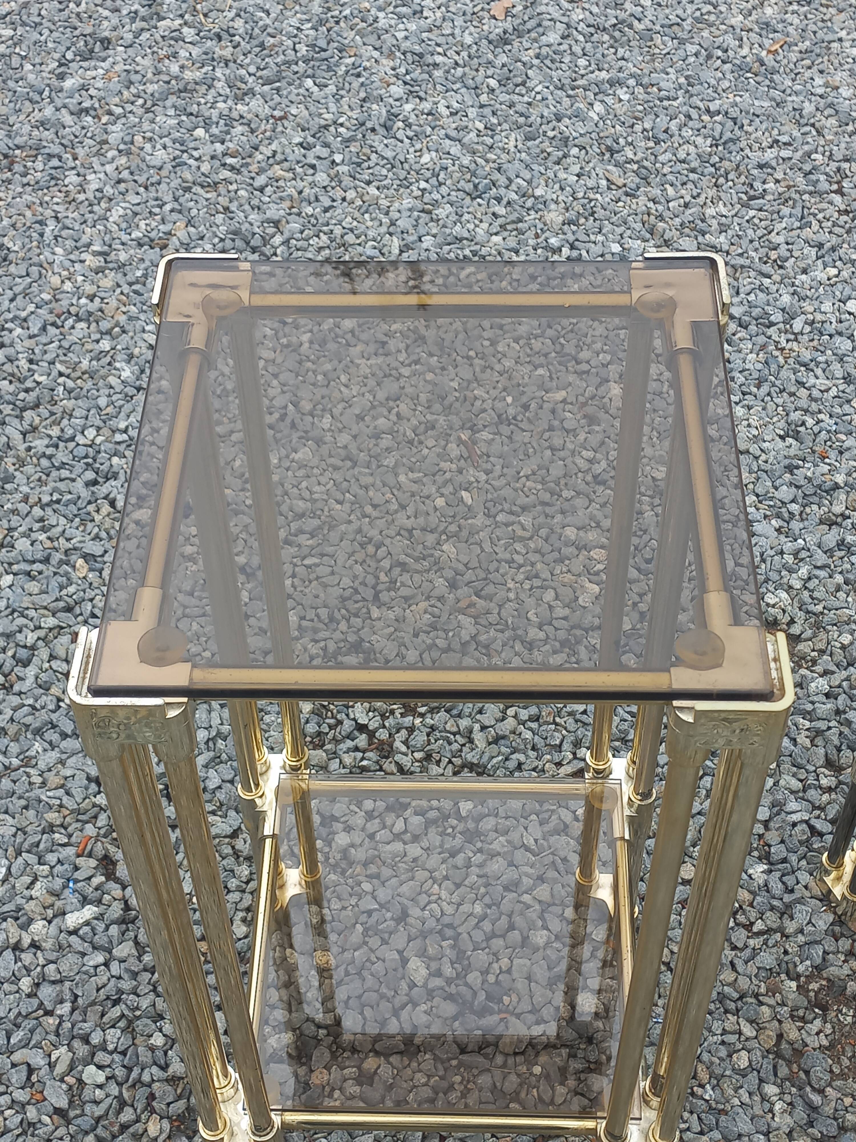 Pair of Hollywood Regency side tables in gold metal and smoked glass.