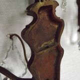 Pair of French antique brass double wall lights with assorted crystals.