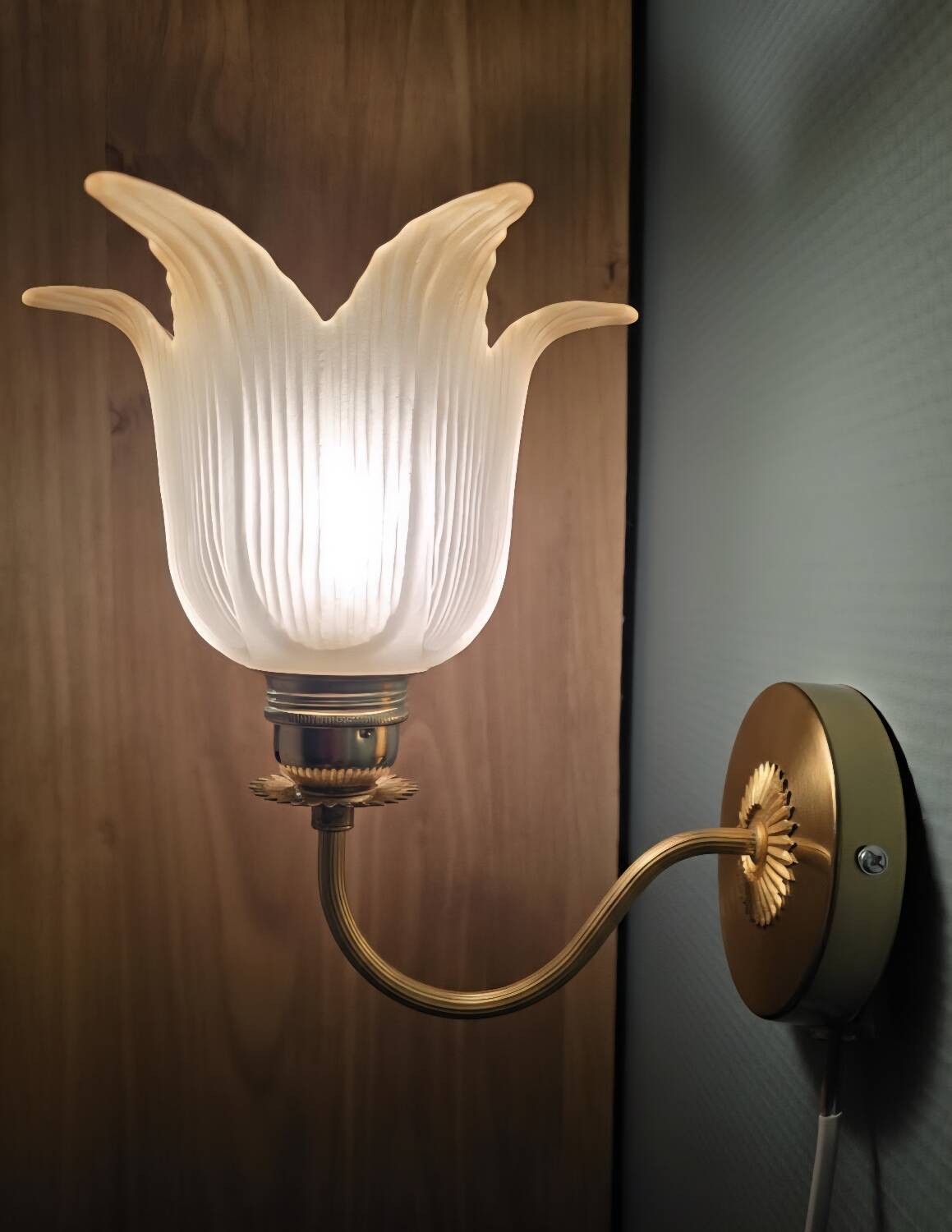 Frosted glass wall sconces and gilded brass in Art Deco style.