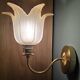 Frosted glass wall sconces and gilded brass in Art Deco style.