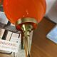 Pair of wall sconces with orange opaline globes and gold metal.