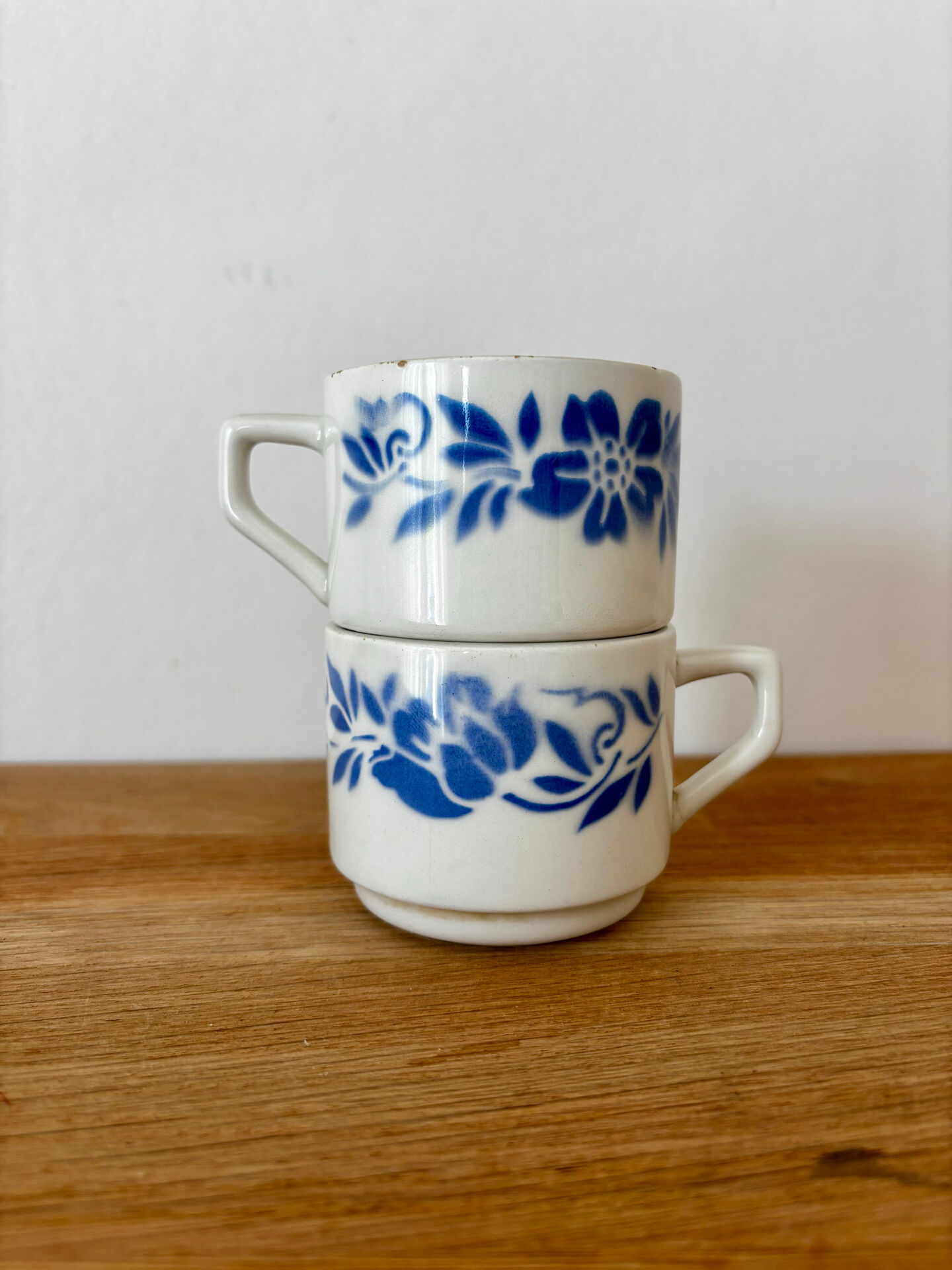 Set of 2 antique earthenware cups with blue floral pattern.