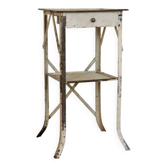 Painted metal side table, patinated white, with a drawer and two shelves