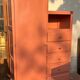 Asymmetrical vintage wardrobe painted in terracotta.