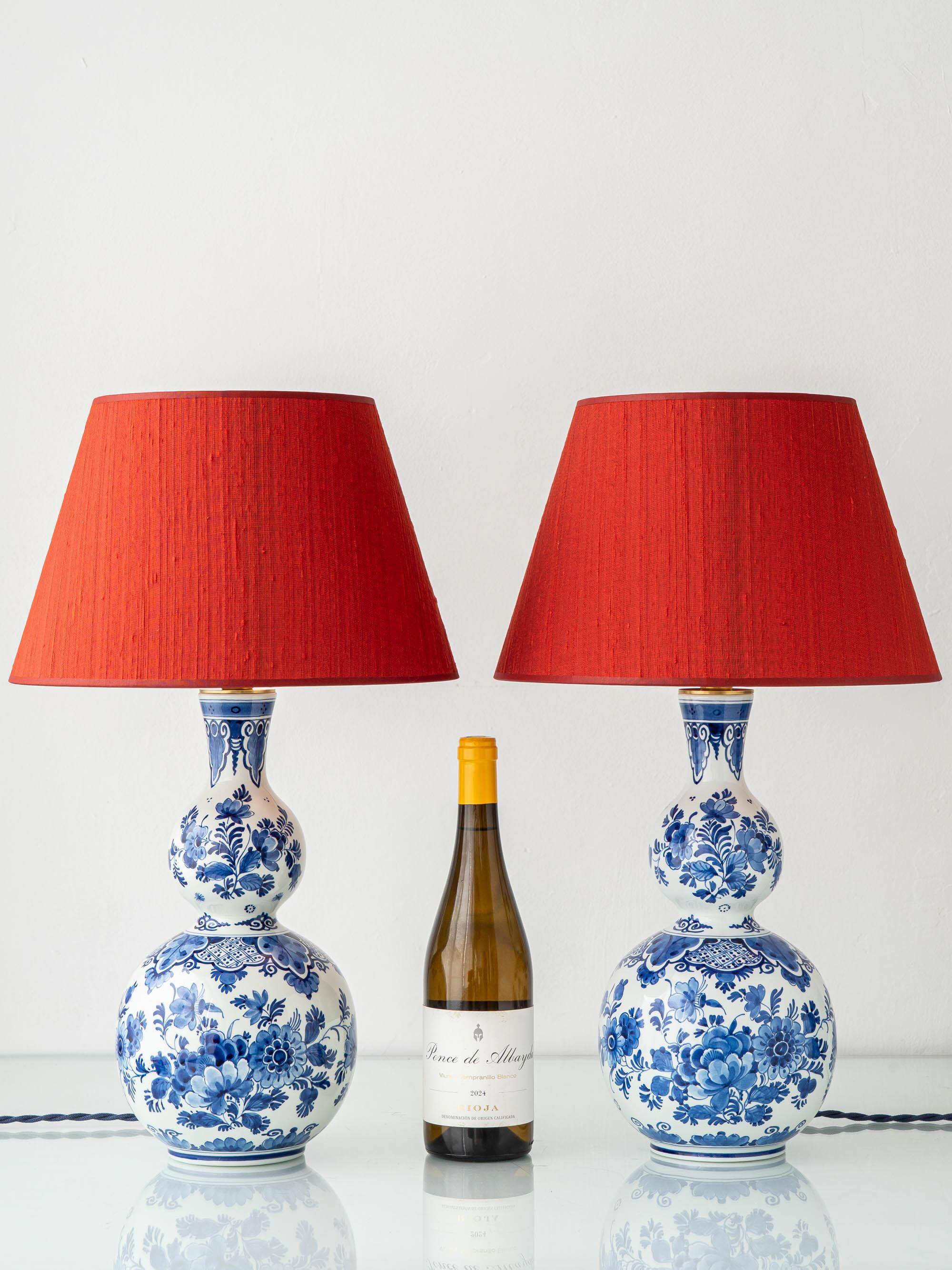 Pair of Royal Delft blue and white ceramic table lamps with new vermilion silk shades.