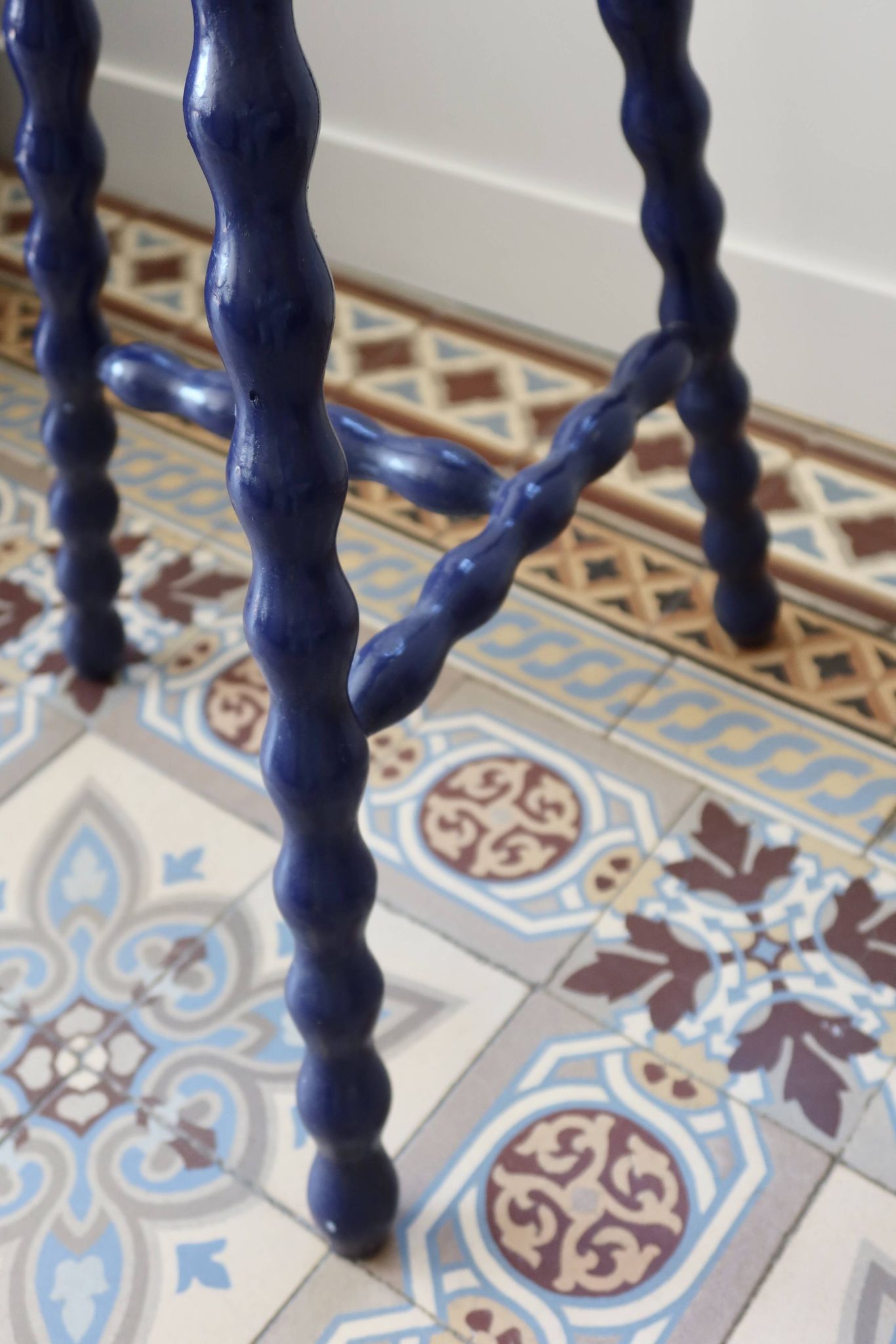 Vintage tripod stool made of turned wood, painted blue.