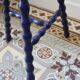 Vintage tripod stool made of turned wood, painted blue.