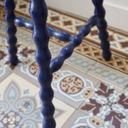 Vintage tripod stool made of turned wood, painted blue.