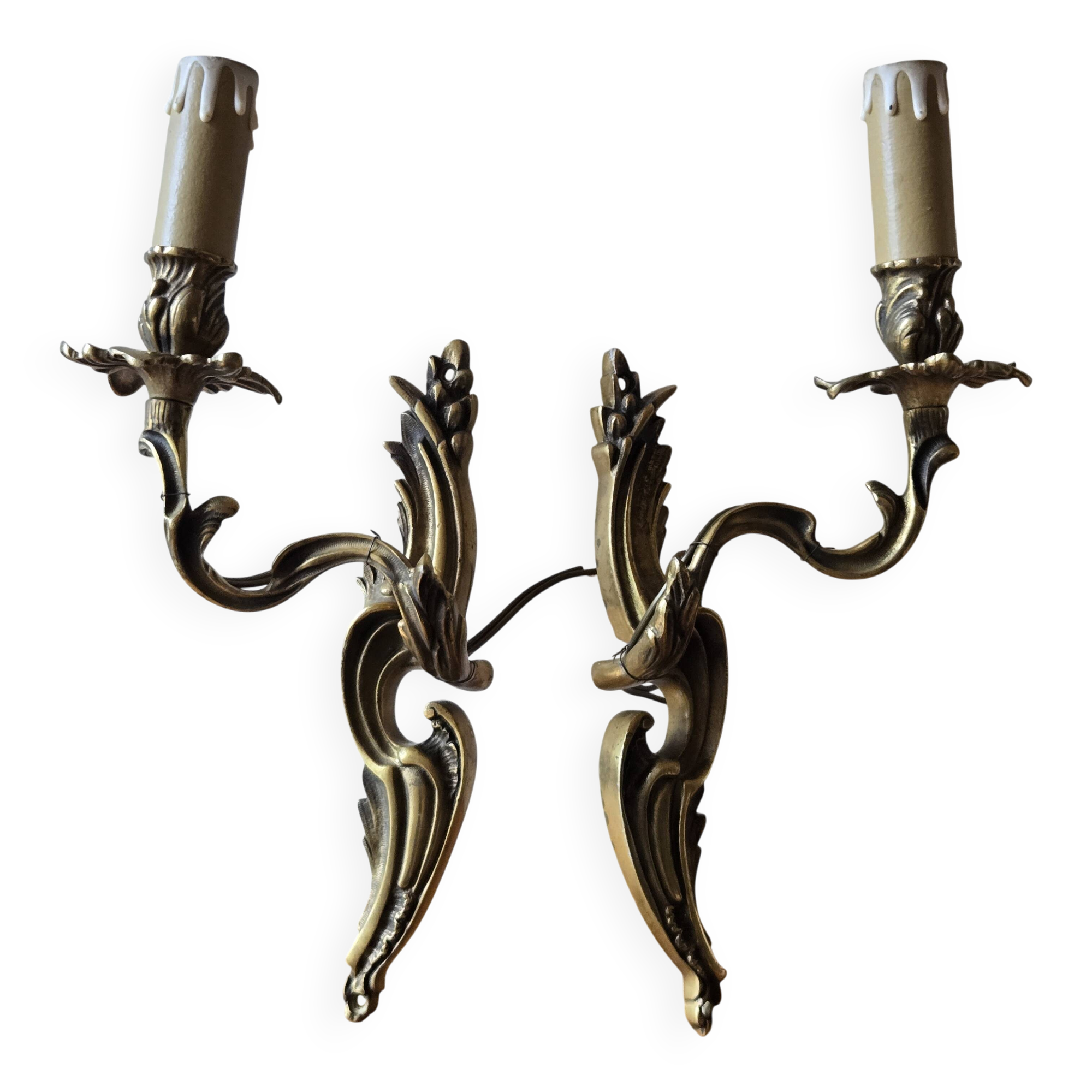 Pair of symmetrical gold wall sconces in baroque style made of bronze.