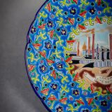 Longwy plate with polychrome enamels, decorated with the "City of Iron" motif.