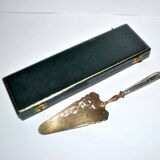 Antique silver-plated pie server with a brass blade decorated with roses.