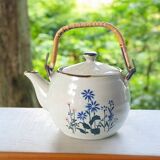 Flowery stoneware teapot with rattan handle.