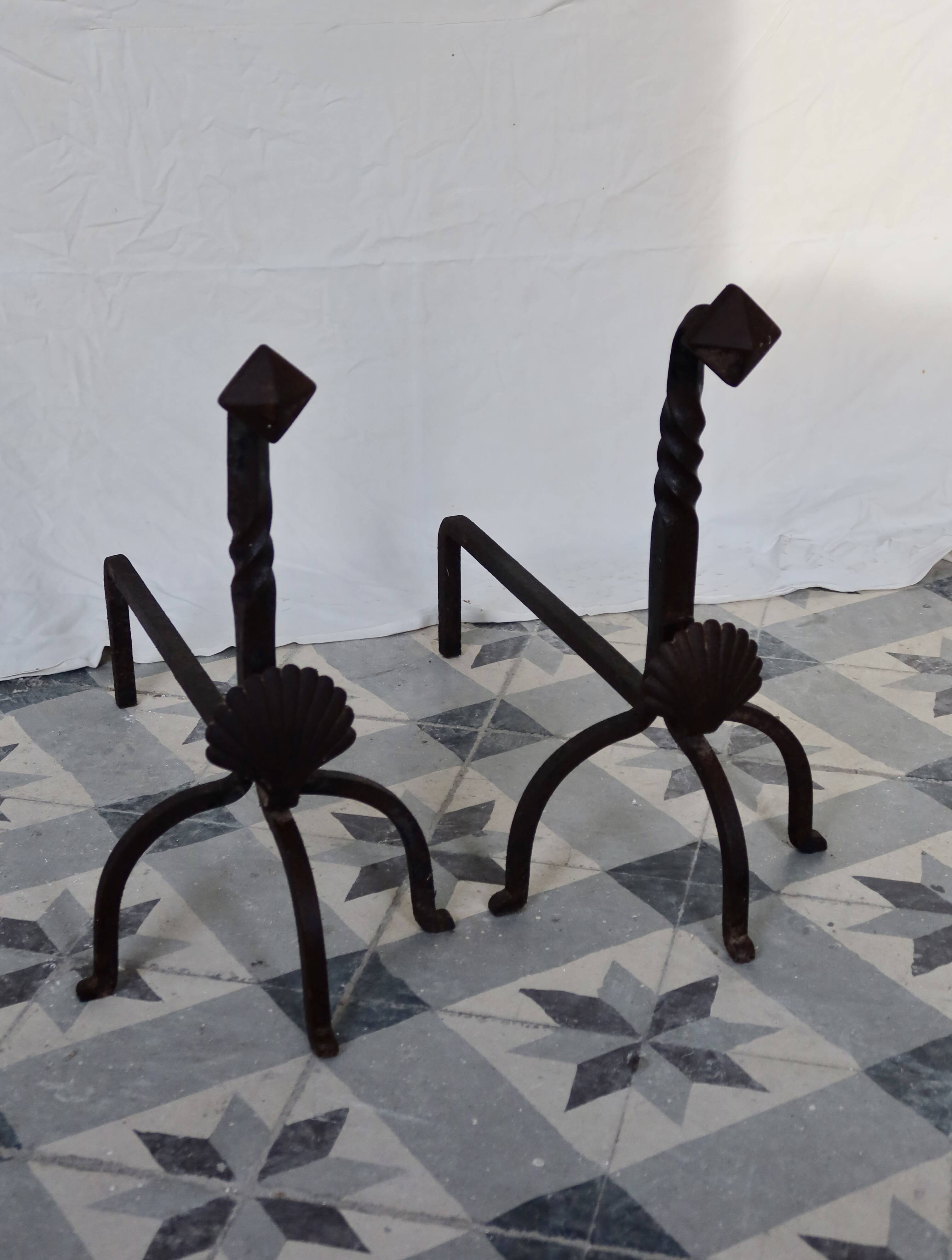 Vintage metal and cast iron fire dogs with shell motif.