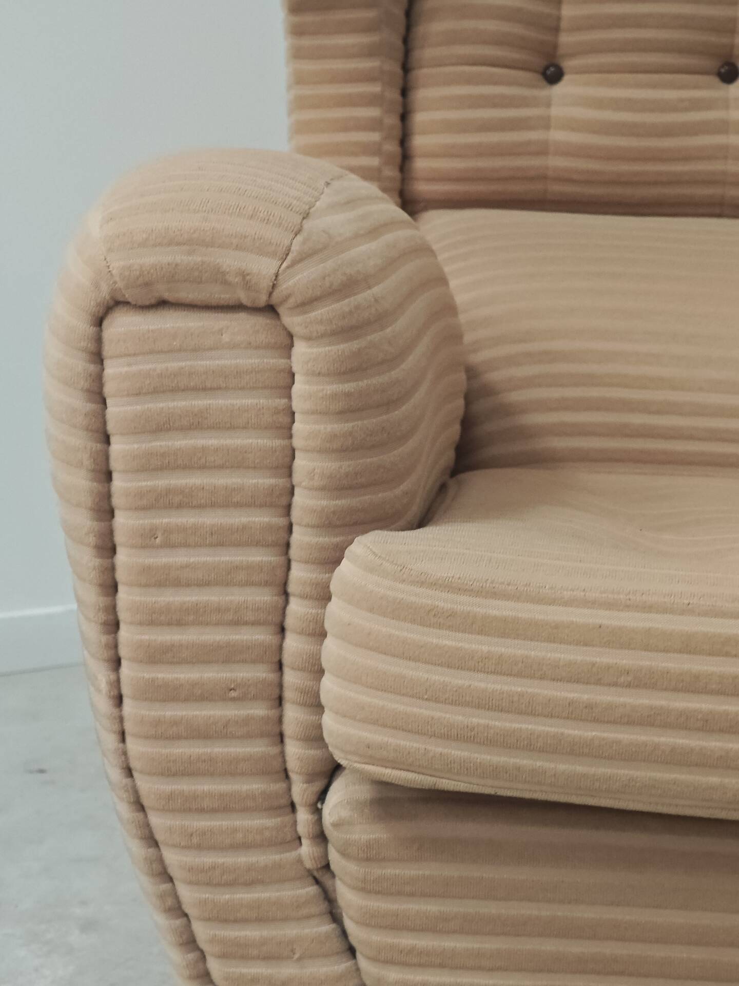 Beige wingback armchair and TVAR footrest, former Czechoslovakia.
