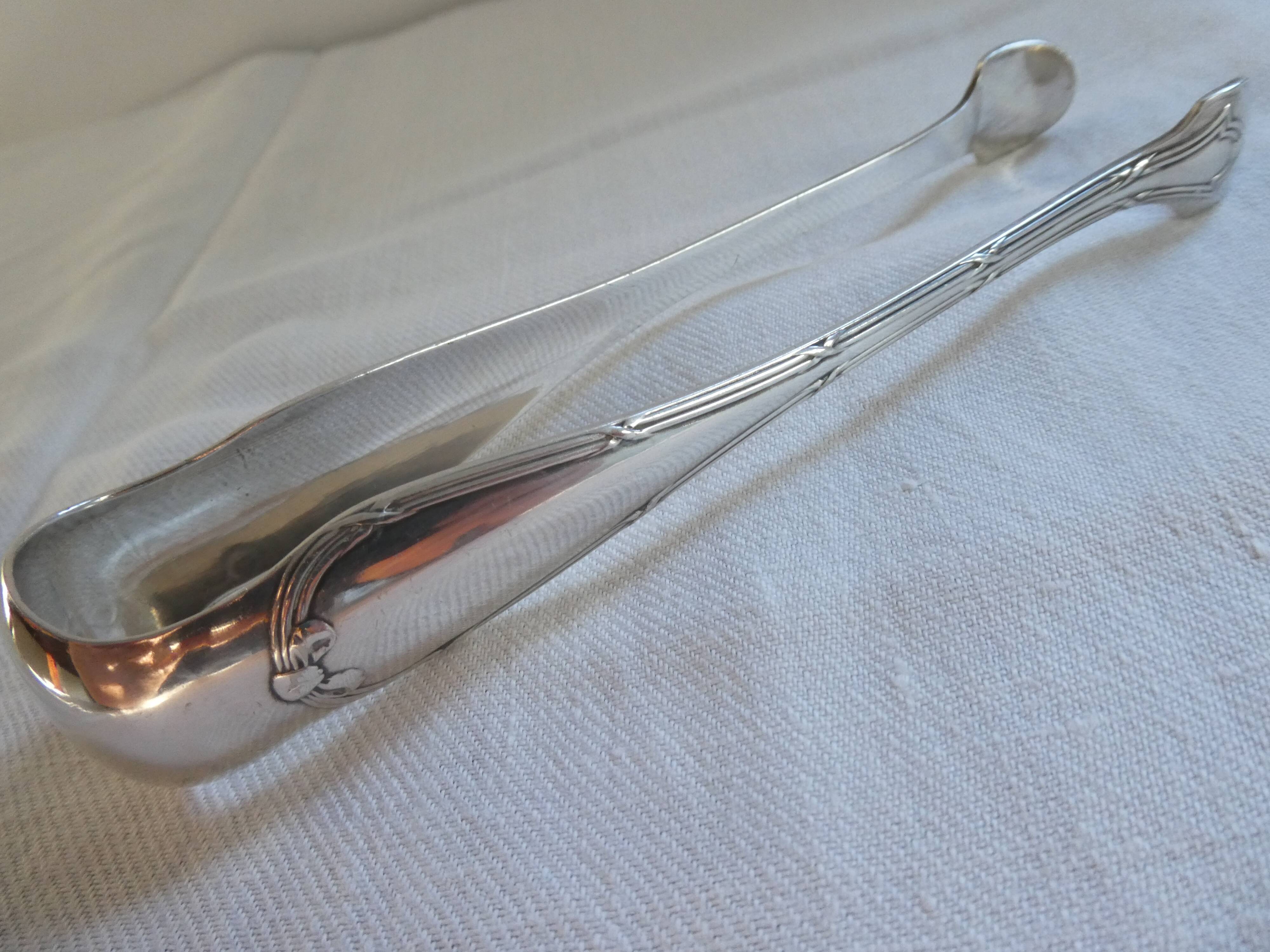 Christofle Silver-plated metal sugar tongs with crossed ribbon bow design