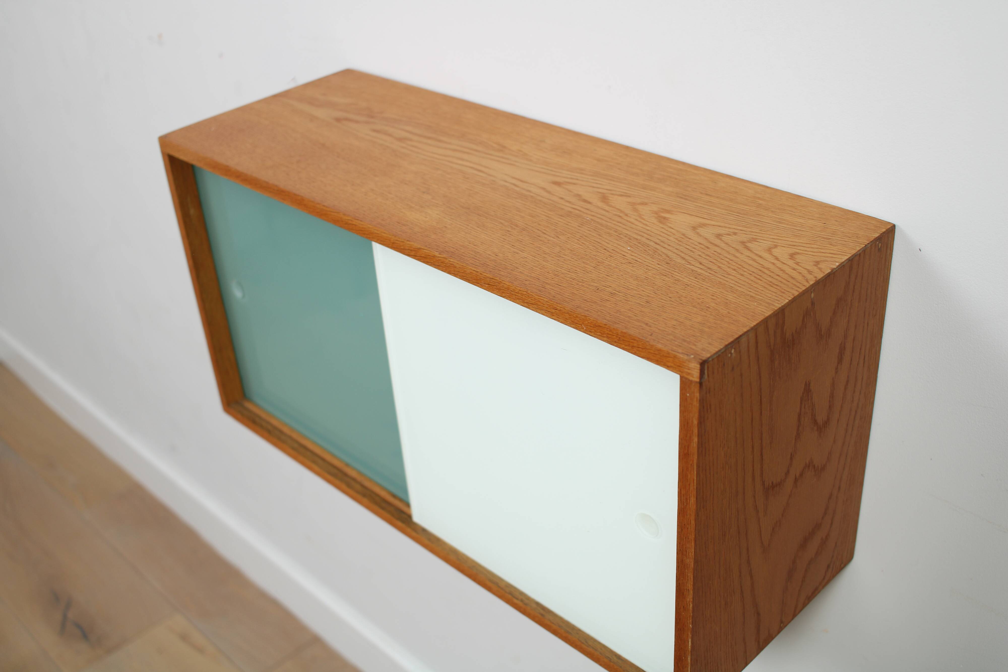 A vintage mid-century wall hung oak cabinet, green & white glass doors