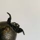 Antique decorative cup in hammered metal with putto design.