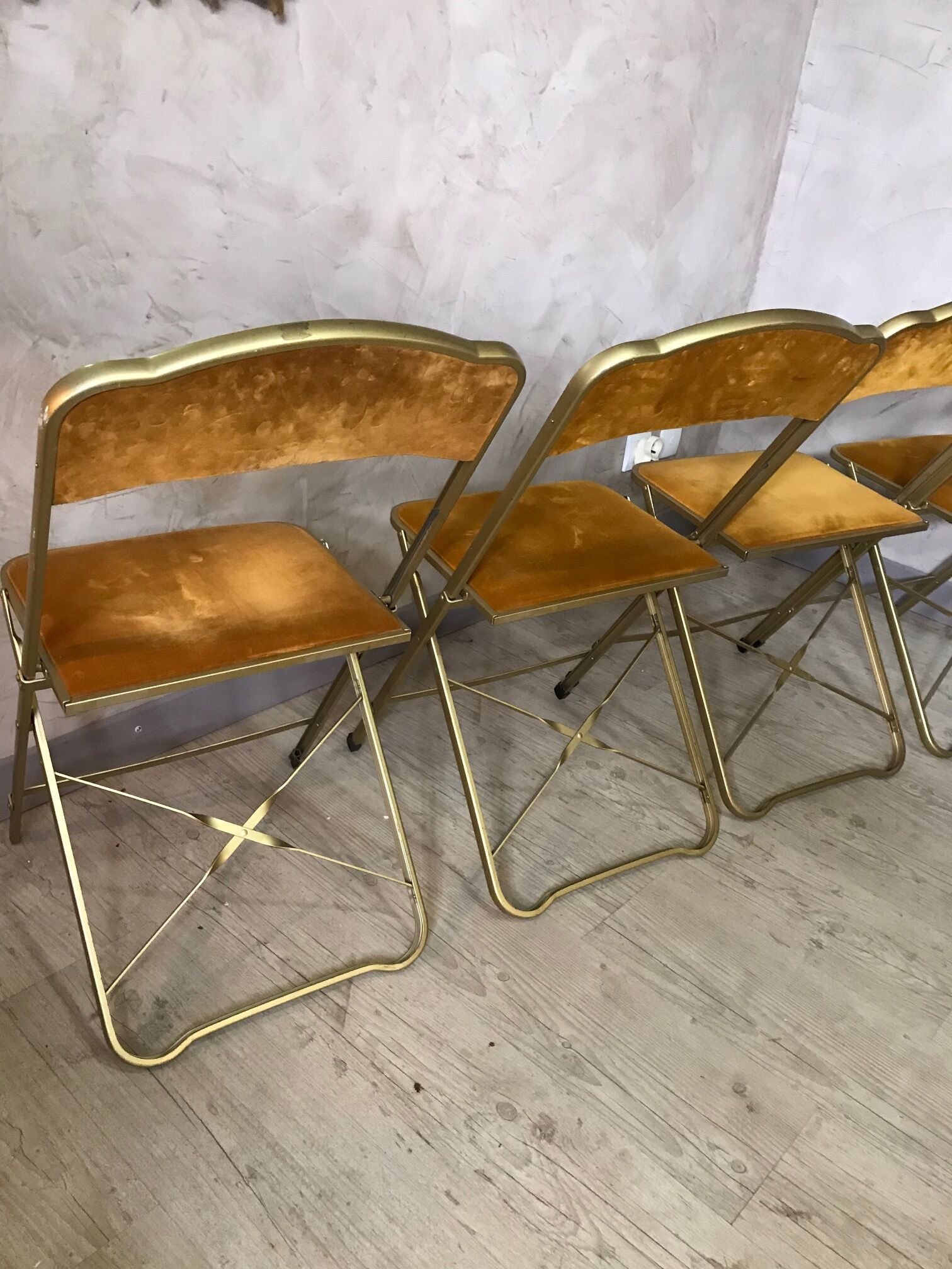 Four folding velvet and brass chairs