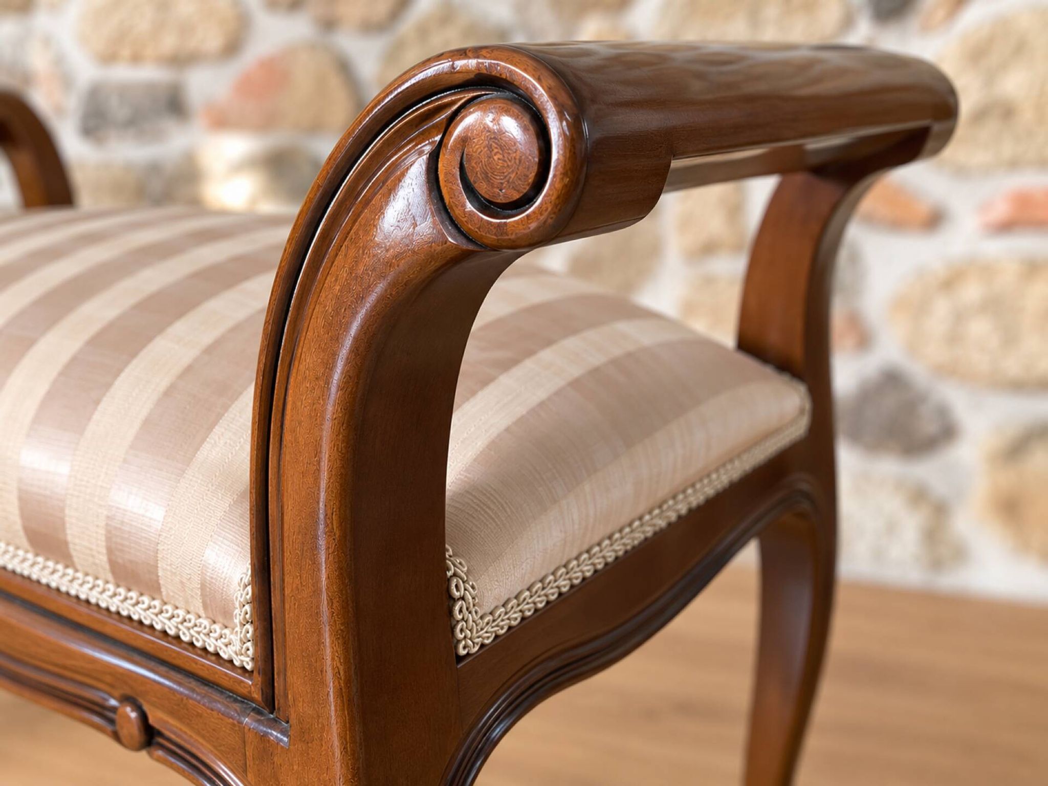 Two-seater bench in carved wood, with curved armrests.