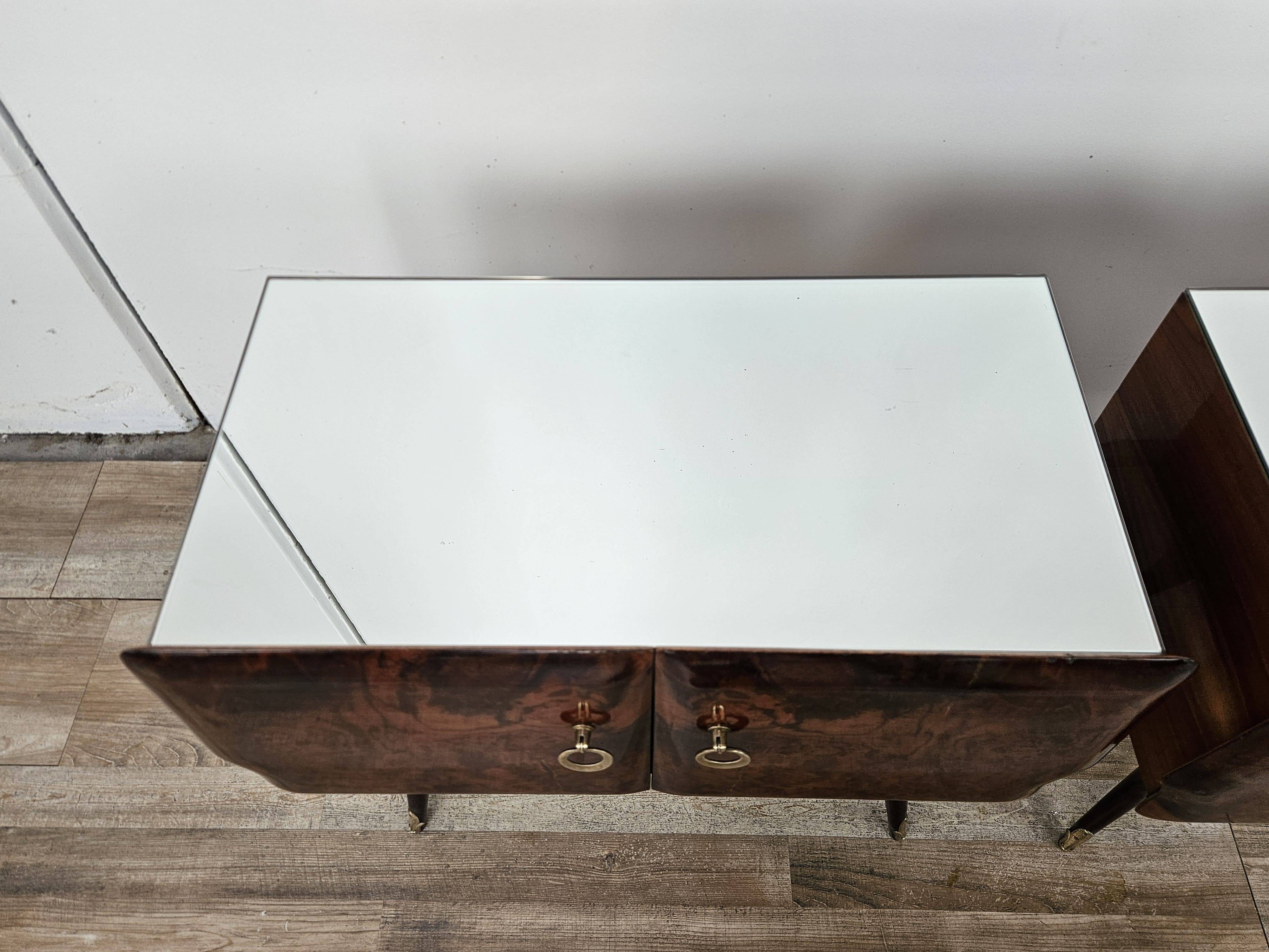 Mid-century mahogany bedside tables with mirrored tops.