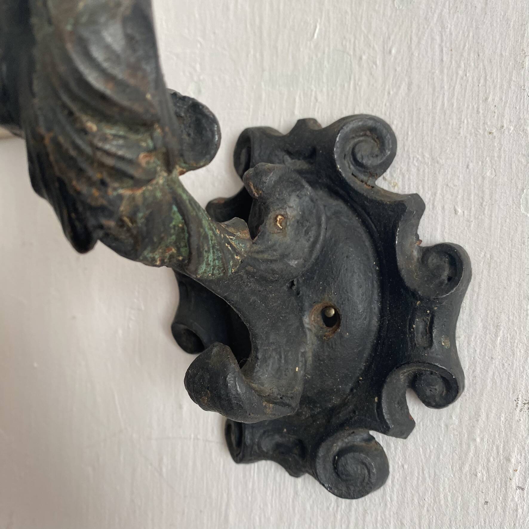 Antique cast iron coat hook with swimmer and shell basin.