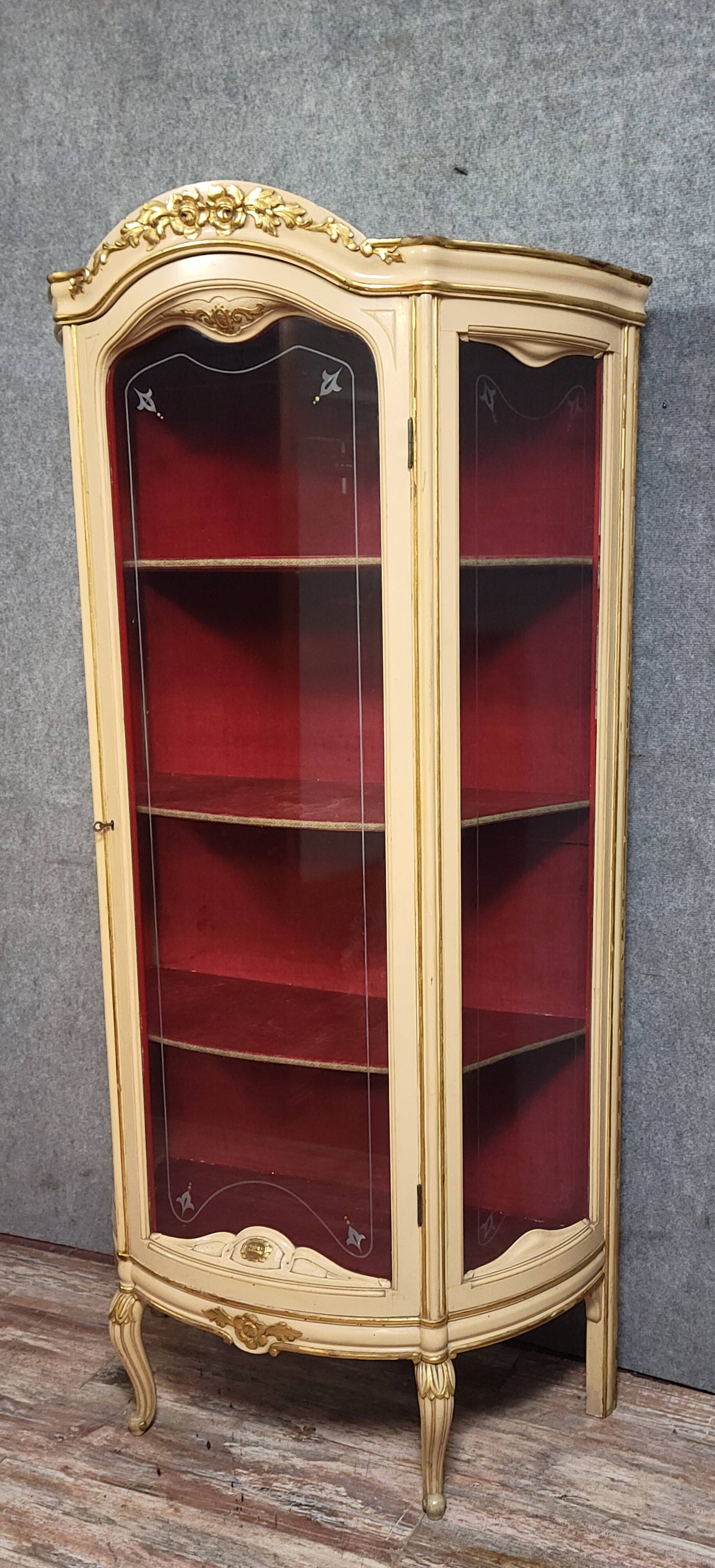 Curved display cabinet in Louis XV style, in cream lacquered wood enhanced with gilding.