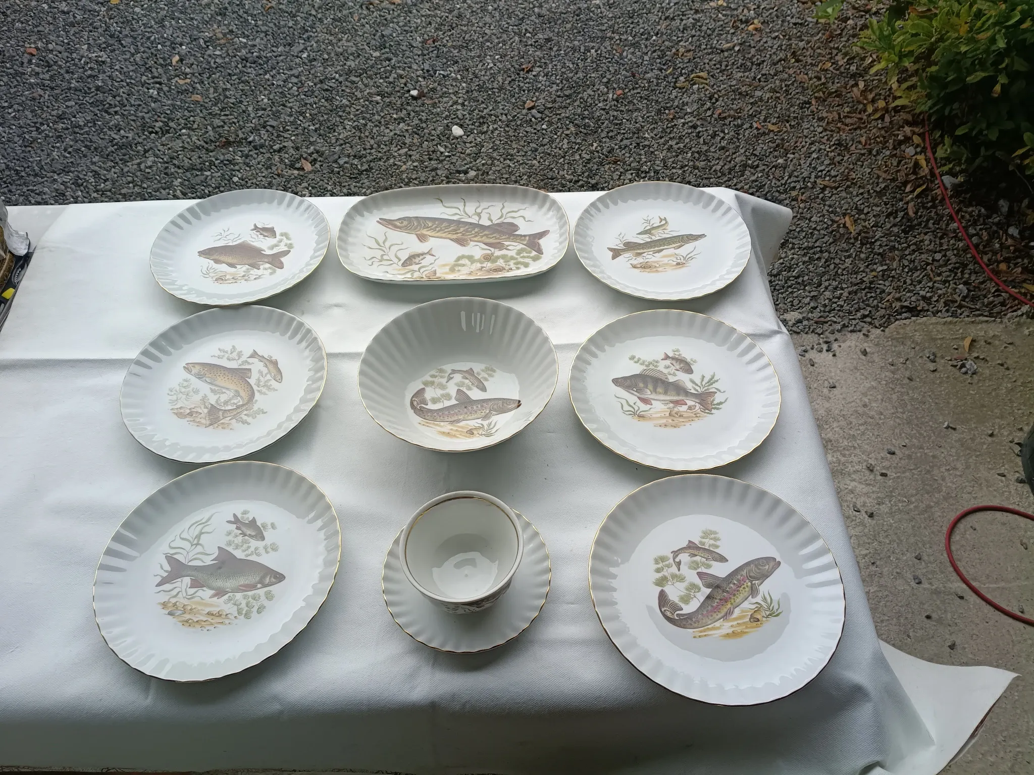 vintage porcelain dinner service with fish pattern and gold trim