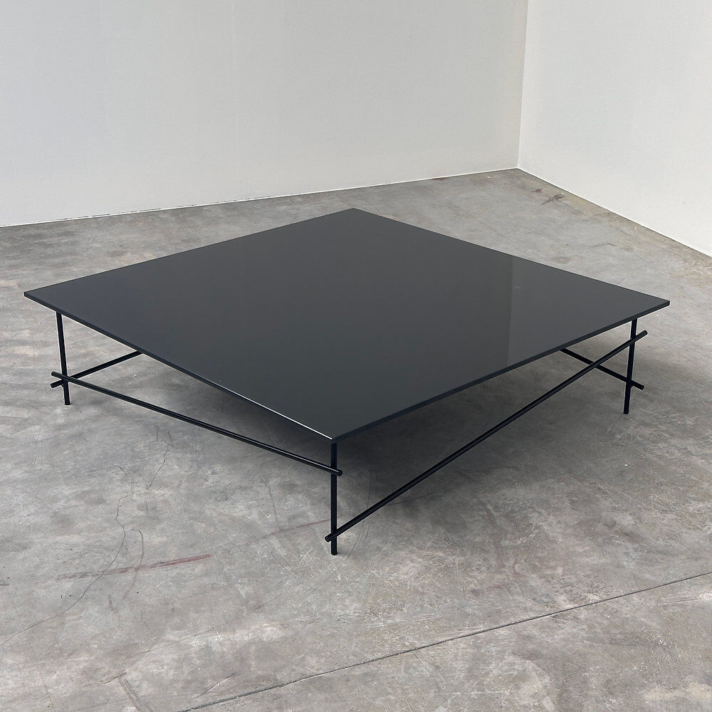 Minimalist black glass coffee table with industrial metal base