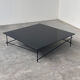 Minimalist black glass coffee table with industrial metal base