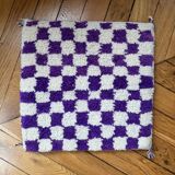 Square cushion cover with a checkered pattern.