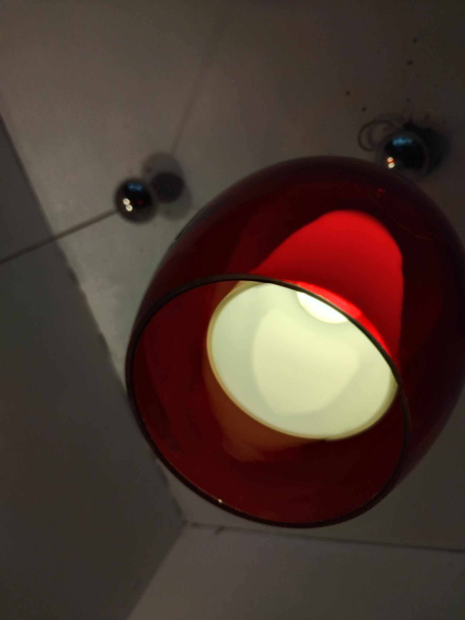 Pair of conical pendant lights in red tinted glass