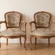 Pair of Louis XV/XVI armchairs in carved wood and floral fabric.