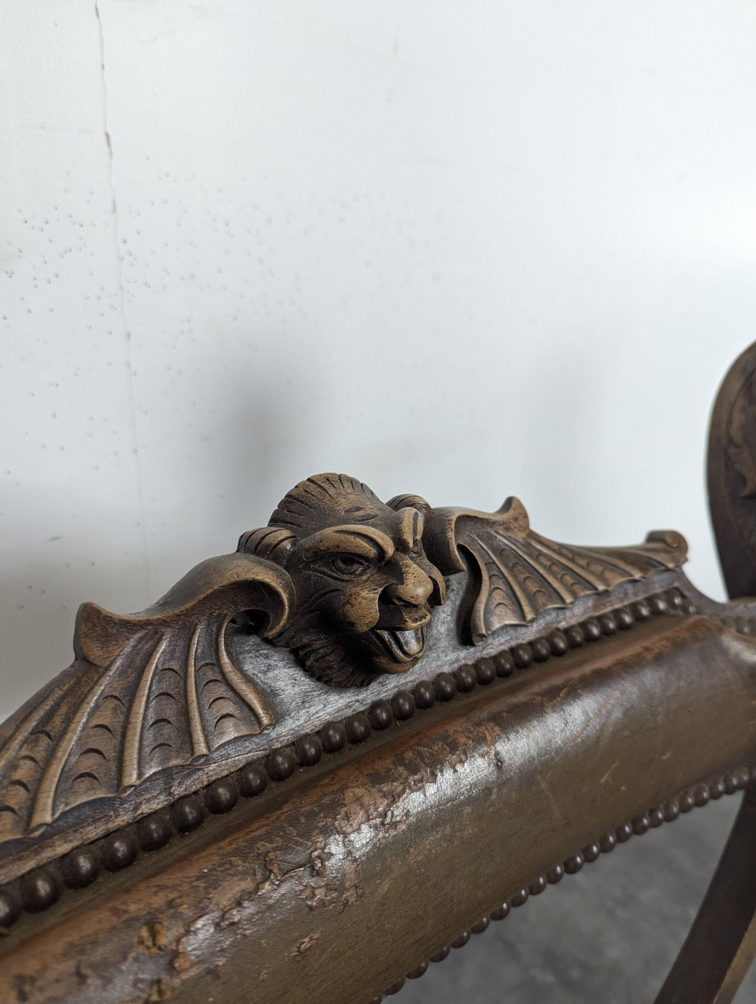 Curule chair Dagobert in carved walnut with lion heads.